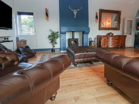 A living room with a fireplace and seating area at The Colonnade in Trefnant