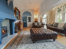 A living room with a fireplace and seating area at The Colonnade in Trefnant