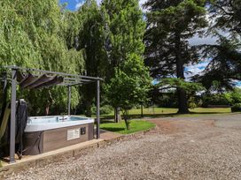 A hot tub under a canopy with trees in the background at The Colonnade in Trefnant