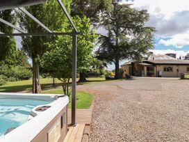 A garden with a hot tub and trees at The Colonnade in Trefnant