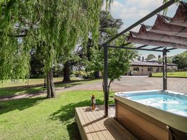 A hot tub on a deck with trees in the background at The Colonnade Trefnant