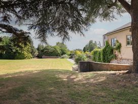 A garden with grass and a tennis net near a house at The Colonnade in Trefnant