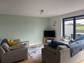 A living room with sofas and a television at 9 Coastguard Cottages Woolacombe