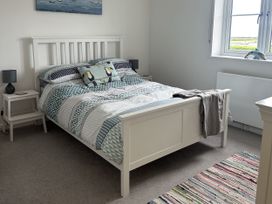 A bedroom with a bed and bedside tables at 9 Coastguard Cottages in Woolacombe