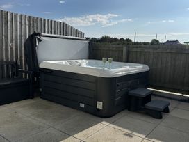 A hot tub with glasses on the side in an outdoor area at 9 Coastguard Cottages Woolacombe