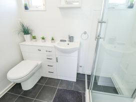 A bathroom with a toilet sink and shower enclosure at 68 Cherry Park in Chapel St Leonards