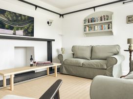 A living room with a sofa and books on a shelf at Tethers End Lindeth near Bowness-On-Windermere