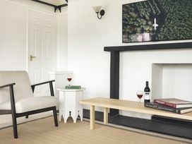 A living room with a chair and a coffee table at Tethers End in Lindeth near Bowness-On-Windermere