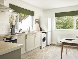 A kitchen with a sink, fridge, washing machine, and kitchen counter at Tethers End in Lindeth near Bowness-On-Windermere