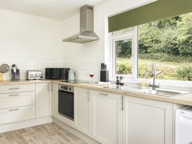 A kitchen with appliances and a window at Tethers End in Lindeth near Bowness-On-Windermere