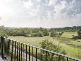 A view of a field and trees from a balcony at Tethers End in Lindeth near Bowness-On-Windermere
