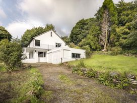 A house with a driveway and trees in the area at Tethers End in Lindeth near Bowness-On-Windermere