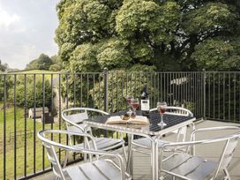 A terrace with a table set for wine at Tethers End in Lindeth near Bowness-On-Windermere