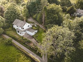 A house surrounded by trees and a garden at Tethers End in Lindeth near Bowness-On-Windermere