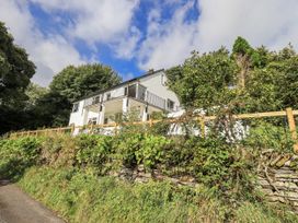A house with a balcony and surrounding vegetation at Tethers End in Lindeth near Bowness-On-Windermere