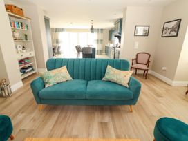 A living room with a teal sofa and bookshelf at Carrowmore North in Doonbeg, County Clare