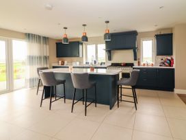 A kitchen with an island and bar stools at Carrowmore North in Doonbeg, County Clare