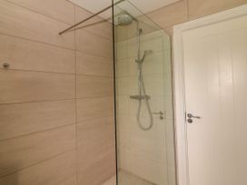 A bathroom with a shower and wall tiles at Carrowmore North, Doonbeg, County Clare