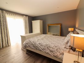 A bedroom with a bed and wardrobe at Carrowmore North in Doonbeg, County Clare