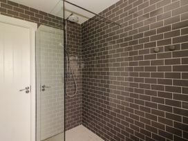 A shower with a glass panel and tile walls at Carrowmore North in Doonbeg, County Clare