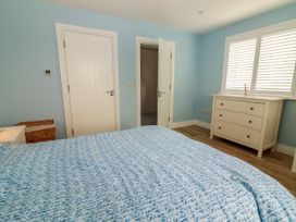 A bedroom with a bed and a dressing table at Carrowmore North in Doonbeg, County Clare