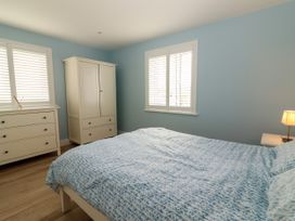 A bedroom with a bed and dresser at Carrowmore North in Doonbeg, County Clare
