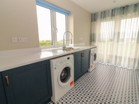A laundry room with washing machines and a sink at Carrowmore North in Doonbeg, County Clare