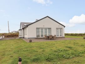 A house with a patio and outdoor seating at Carrowmore North in Doonbeg, County Clare