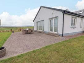 An outdoor patio with a dining table and chairs at Carrowmore North in Doonbeg, County Clare