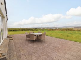 An outdoor patio with a table and chairs at Carrowmore North, Doonbeg, County Clare