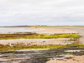 A beach with rocks and seaweed in the foreground at Carrowmore North in Doonbeg, County Clare