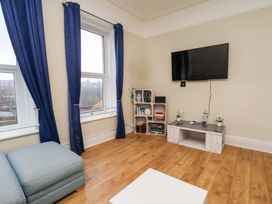 A living room with a television and bookshelf at Wellington Lodge in Bridlington