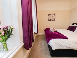 A bedroom with a bed and flowers on a table at Wellington Lodge in Bridlington