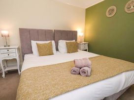 A bedroom with a large bed and bedside tables at Wellington Lodge in Bridlington