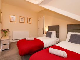 A bedroom with two beds and a table at Wellington Lodge in Bridlington