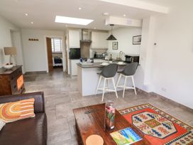 A kitchen with an island and two bar stools next to a living area with a sofa and a coffee table at 3 Palms in Preston Sands