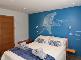 A bedroom with a double bed and rolled towels on a blue runner in 3 Palms Preston Sands