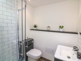 A bathroom with a shower enclosure toilet sink shelf with two plants and heart decoration at 3 Palms in Preston Sands