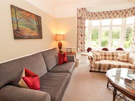 A living room with a gray sofa and checkered couch at Bracken Howe Ambleside