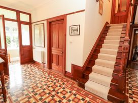 A hallway with a staircase and decorative floor tiles at Bracken Howe in Ambleside