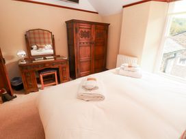 A bedroom with a bed, wardrobe, and dressing table at Bracken Howe in Ambleside