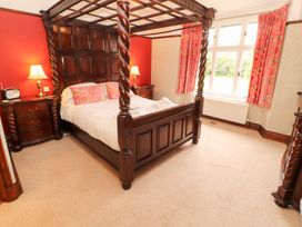 A bedroom with a four-poster bed and nightstand at Bracken Howe in Ambleside