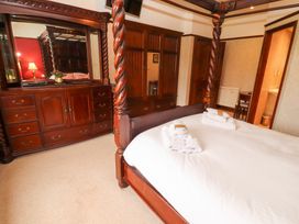 A bedroom with a four-poster bed and wooden furniture at Bracken Howe in Ambleside
