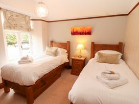 A bedroom with two beds and a nightstand at Bracken Howe in Ambleside