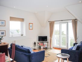 A living room with a sofa and television at 6 Grafton Towers in Salcombe