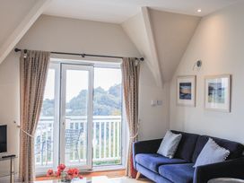 A living room with a sofa and balcony door at 6 Grafton Towers in Salcombe