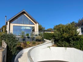 A house with large windows and a pathway at Woodcroft in Pwllheli