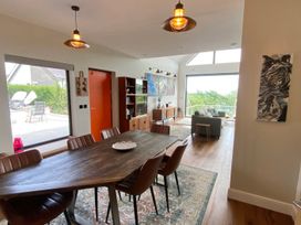 A dining room with a table and chairs at Woodcroft in Pwllheli
