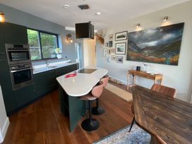 A kitchen with appliances and dining furniture at Woodcroft in Pwllheli