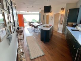 A kitchen with dining table and chairs at Woodcroft in Pwllheli